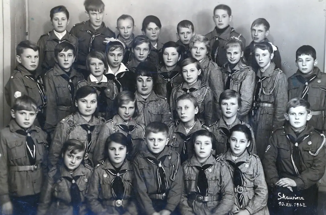 Czarno-białe zdjęcie klasowe: kilkadziesiąt dzieci ustawionych w trzech rzędach.