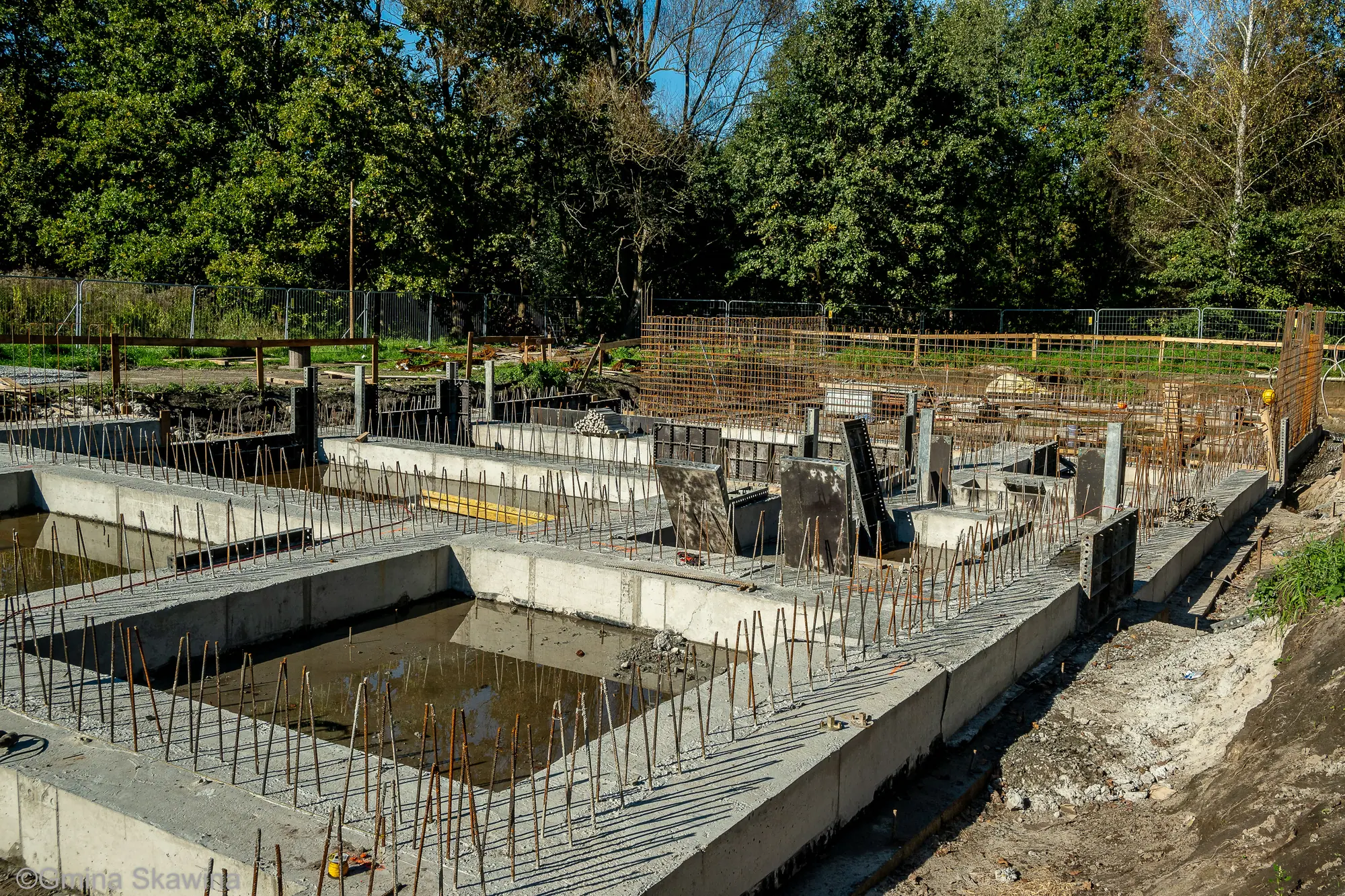 Betonowe ławy i ściany fundamentowe tworzące siatkę pomieszczeń, z prętów zbrojeniowych sterczą wypusty pod ściany kondygnacji.
